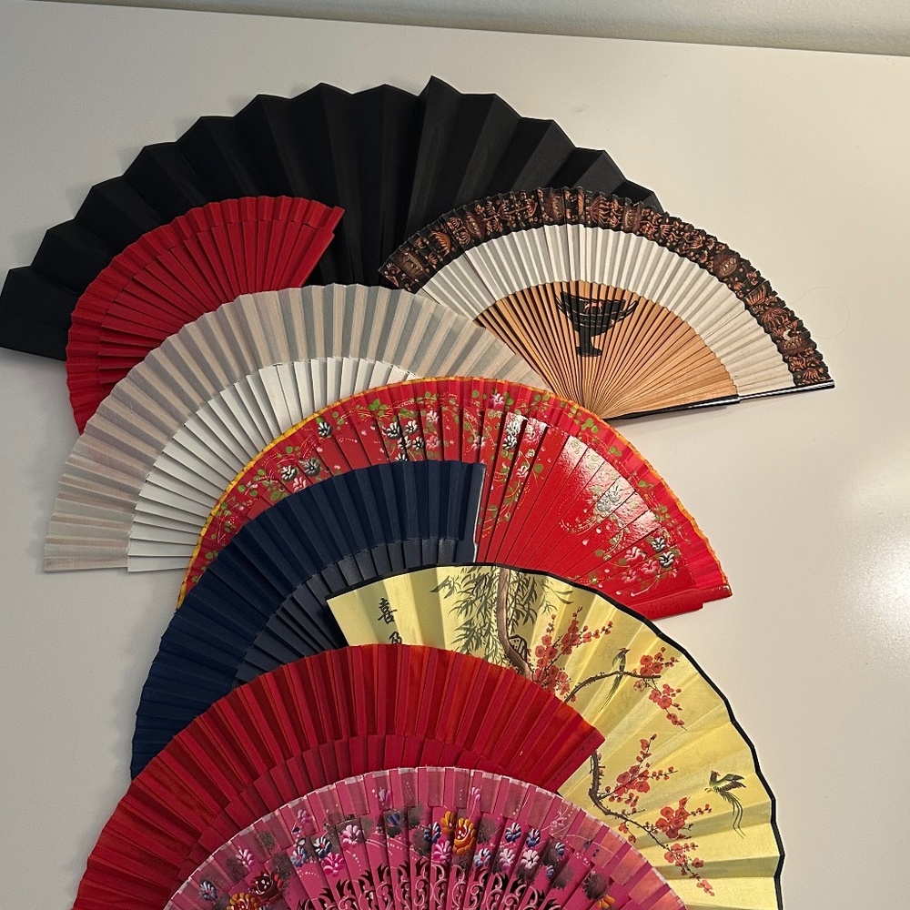 Collection of 9 hand fans, mix of paper and fabric and wood